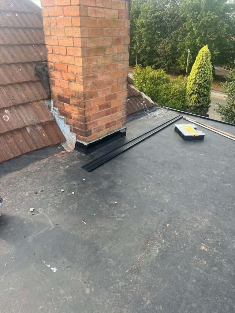 This is a photo of a flat roof which has just been repaired, there is also a chimney stack and some leadwork has also been dressed. Works carried out by Bilston Roofing Repairs